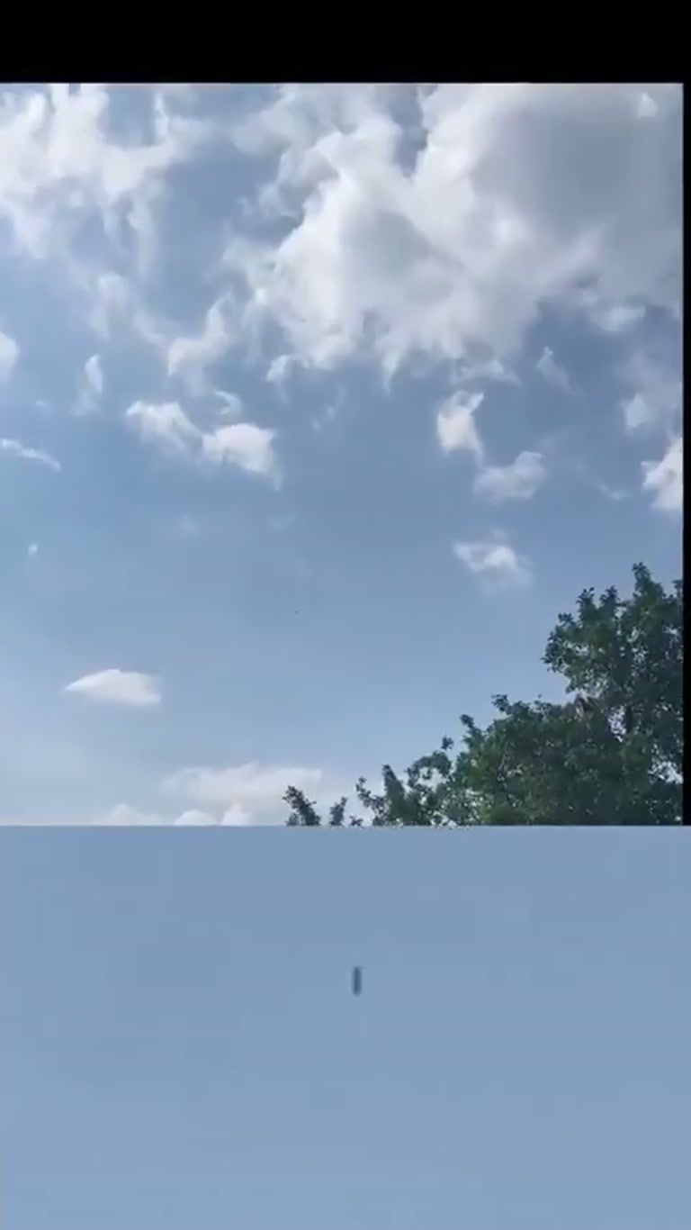 Dark Cylindrical Object Hovers Over Swiss Pasture in Viral Clip