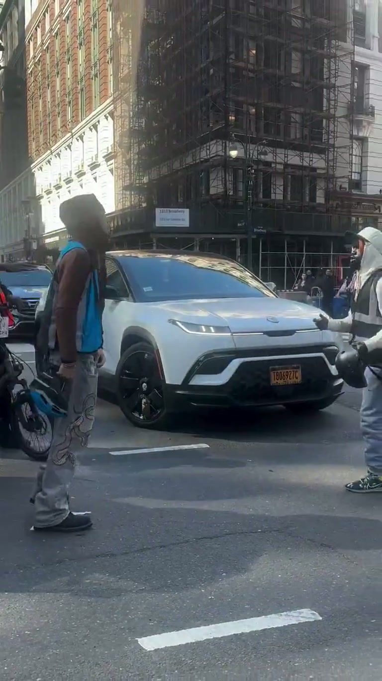 Two delivery drivers brawl on a New York street as crowds watch