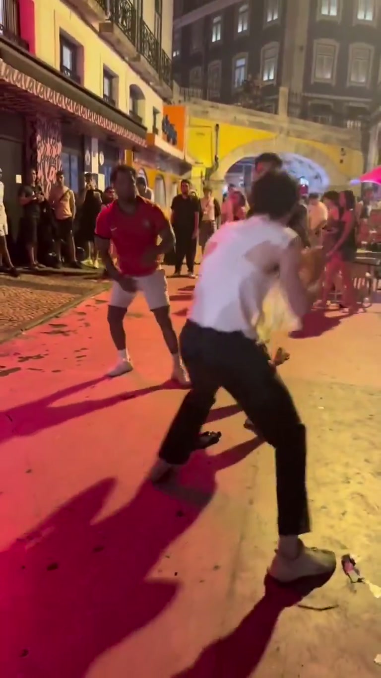 Night Street Scuffle Ends With a Shirtless Walk and a Crowd