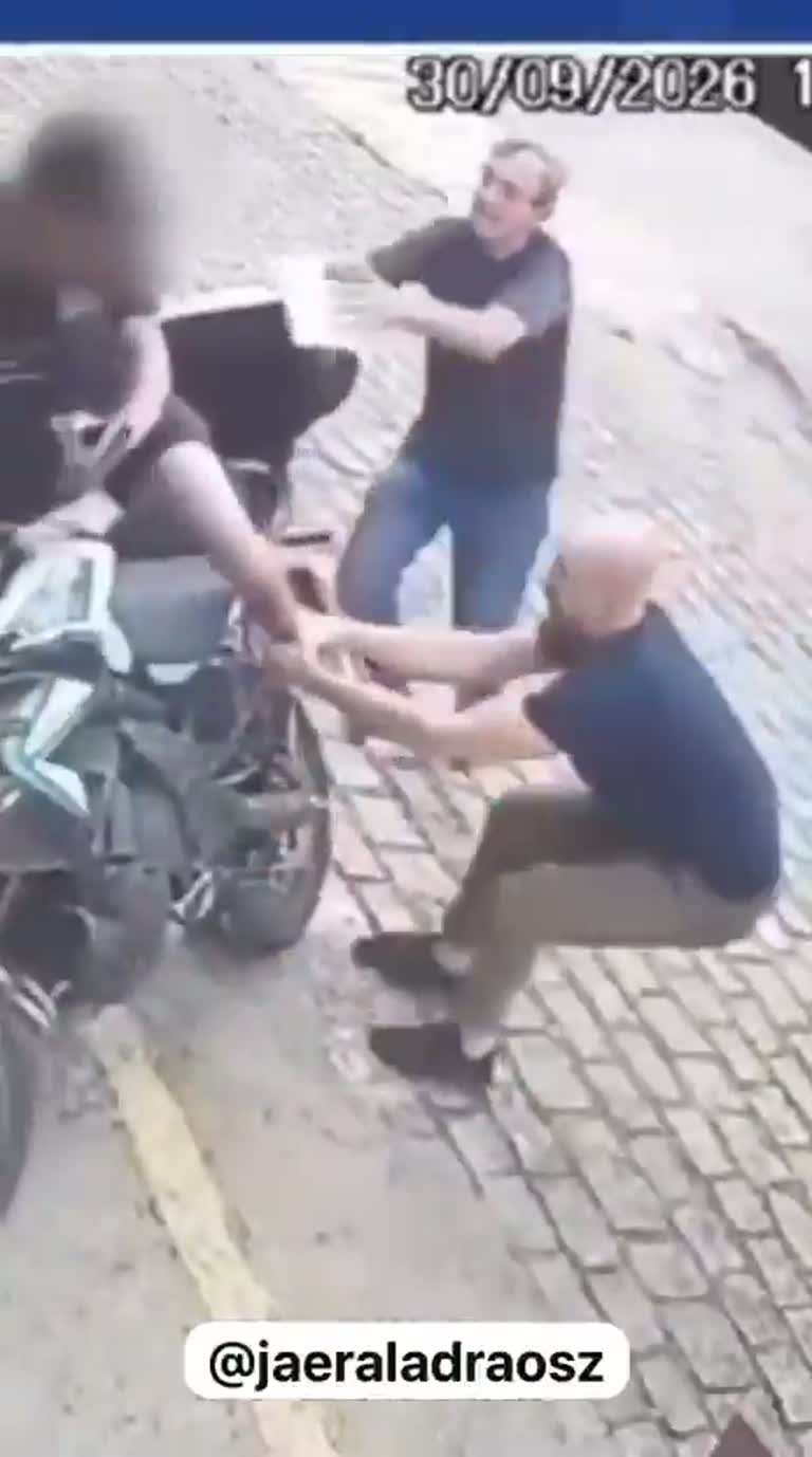 Crowd Pins Man on Street as Elderly Woman Arrives With Broom