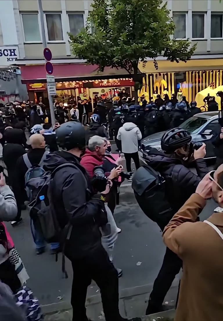 Dusk Falls, Phones Rise, and One Street Turns Into a Standoff