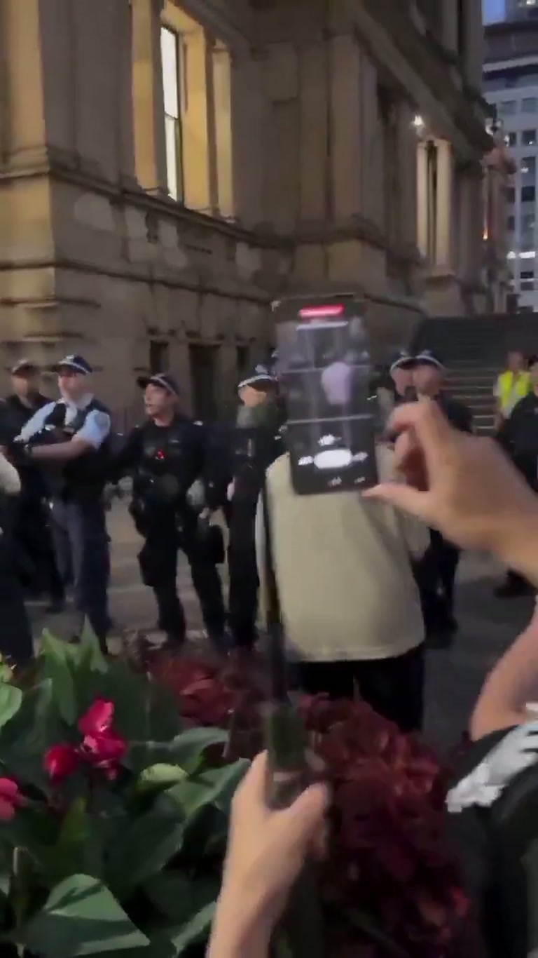 Officers Close In as a Man Kneels in Prayer on a Busy Street