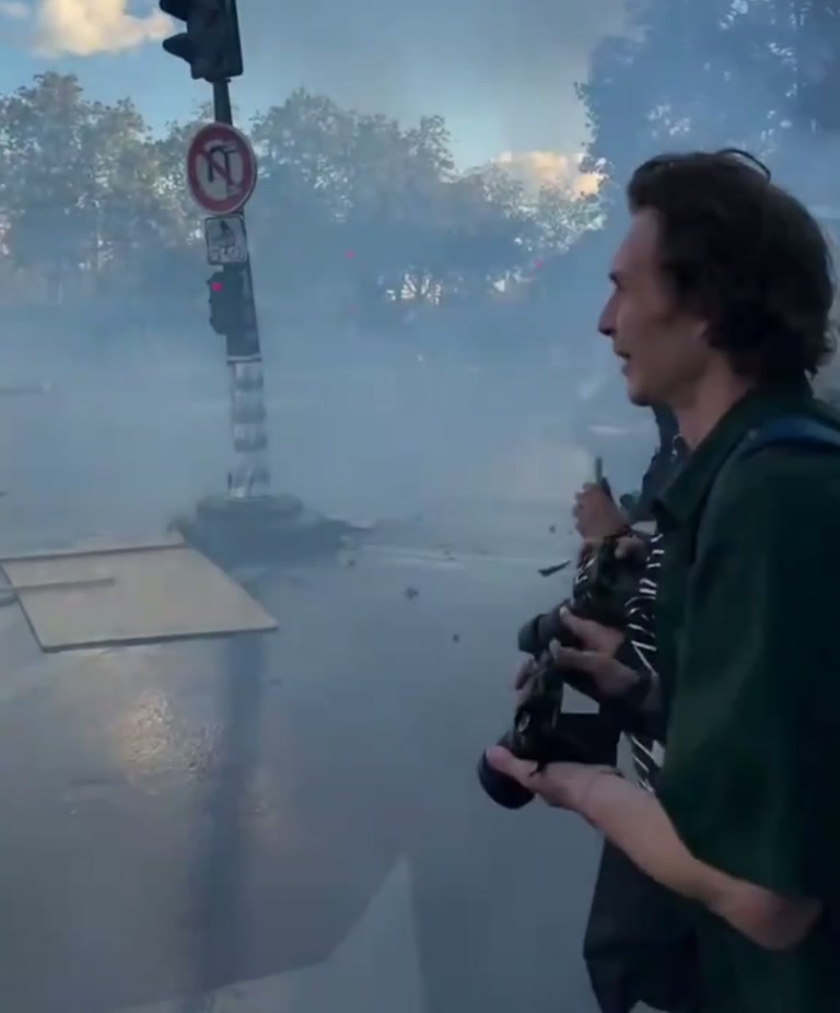 Thick Smoke, a Wet Street, and One Figure Who Keeps Walking