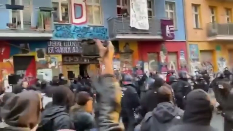A Colorful Street, a Wall of Helmets, and One Raised Fist