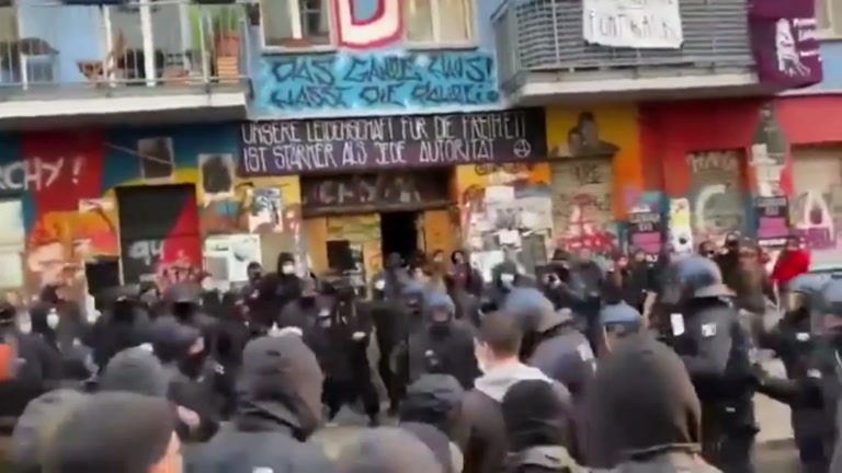 A Colorful Street, a Wall of Helmets, and One Raised Fist