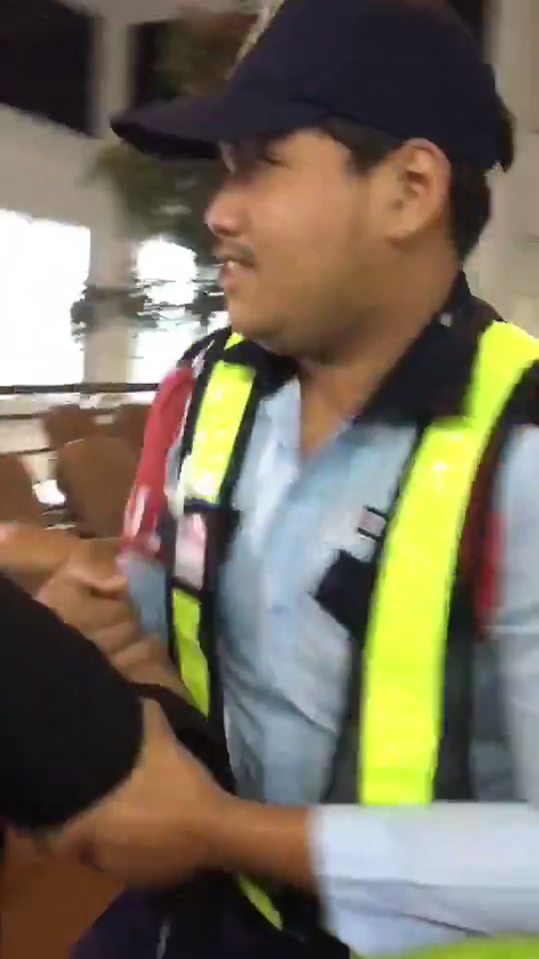 A Purple Mask, a Steady Arm, and an Airport Hall That Goes Still