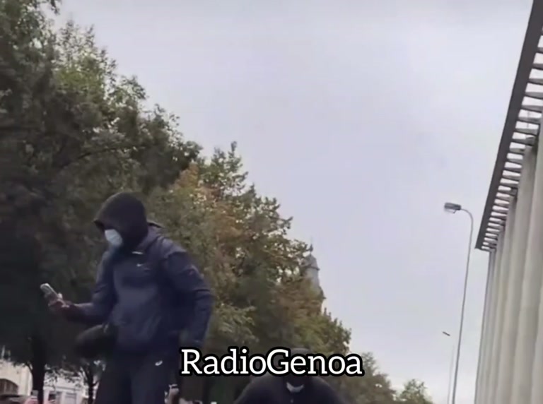 A Crowd Freezes on a Brussels Street as One Man Climbs a Car