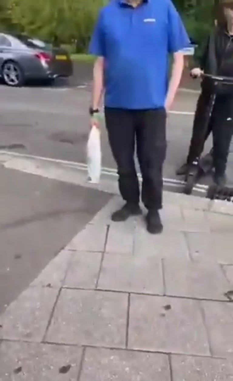 Pavement Standoff: Store Guard and Woman Wait as Police Pull Up