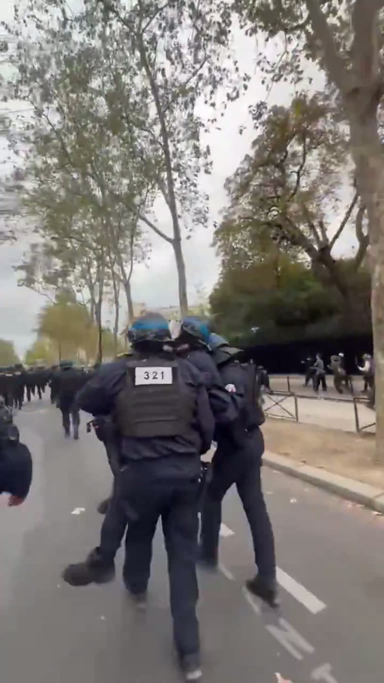 French riot police carry injured comrade from chaotic street clash