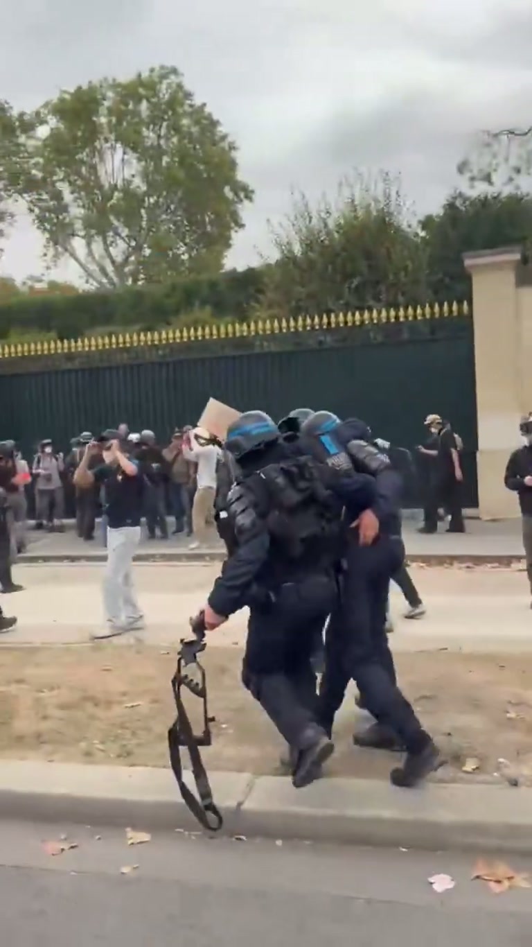 French riot police carry injured comrade from chaotic street clash