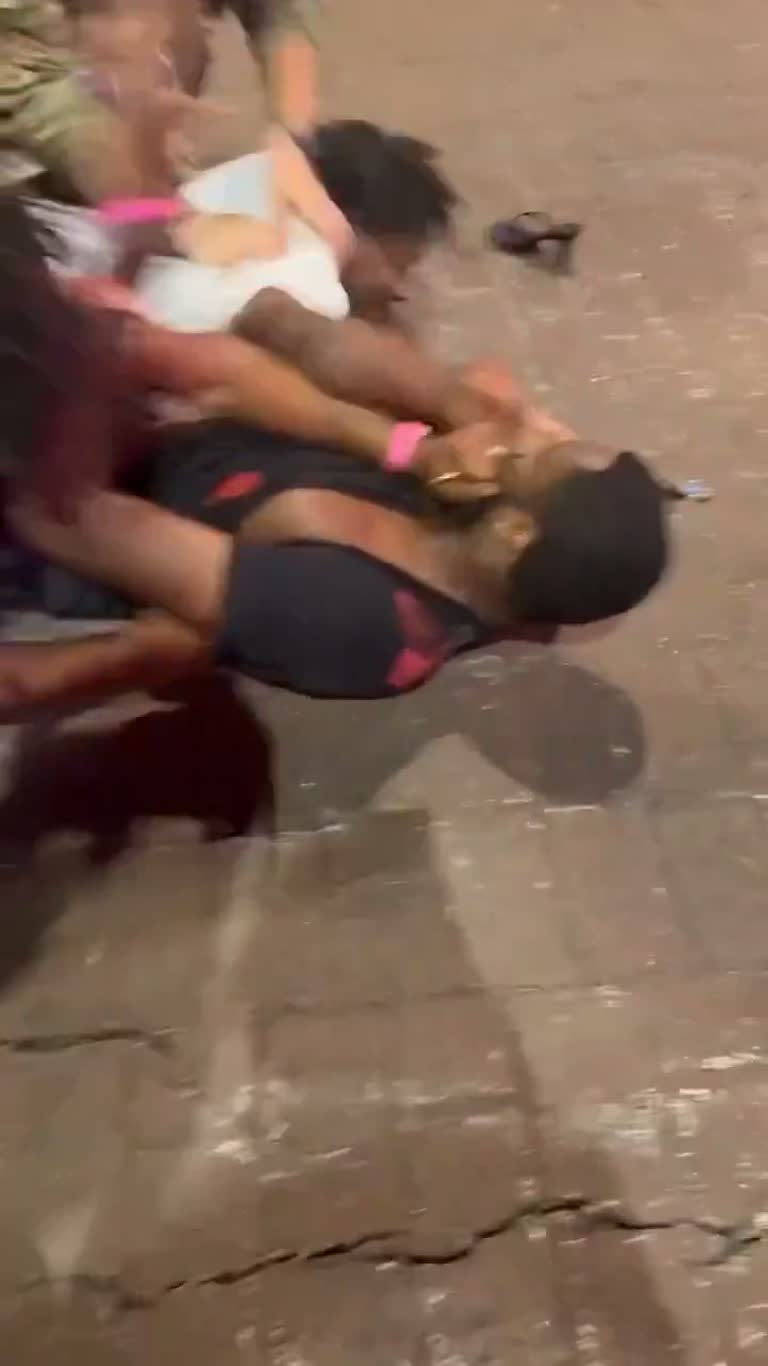 Chaos on the pavement as a soldier steps in to break up a street brawl