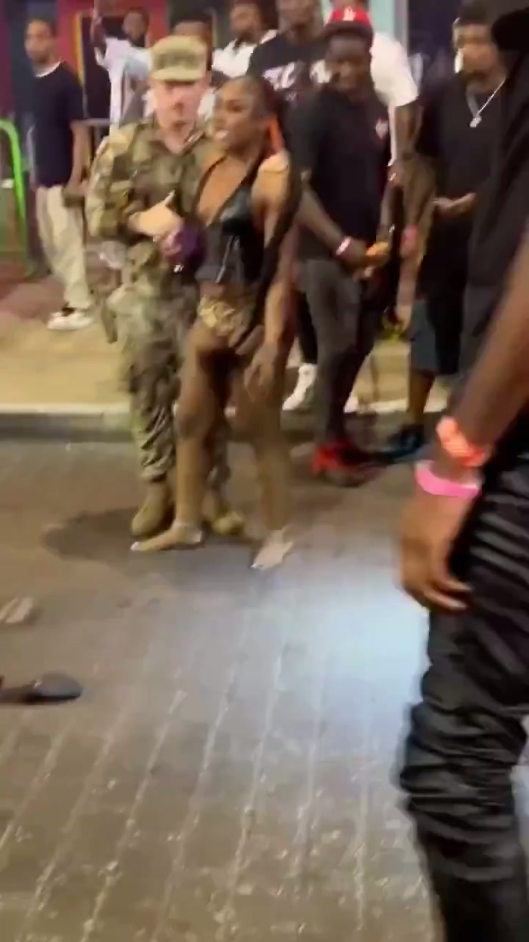 Chaos on the pavement as a soldier steps in to break up a street brawl